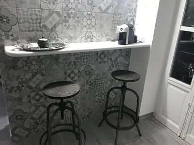 a kitchen with two bar stools and a counter with a sink at Home 3L in Palermo
