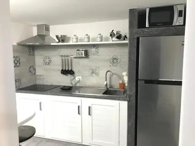 a kitchen with white cabinets and a stainless steel refrigerator at Home 3L in Palermo
