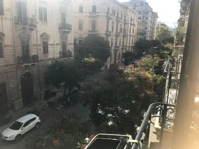 a white car parked on a street with buildings at Home 3L in Palermo