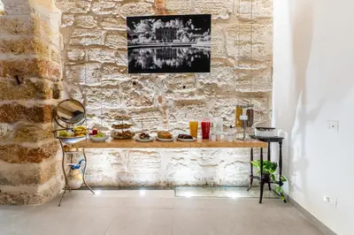 a table in a room with a stone wall at Khalisah in Palermo