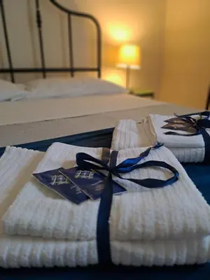 two folded towels with a blue ribbon on a bed at 
