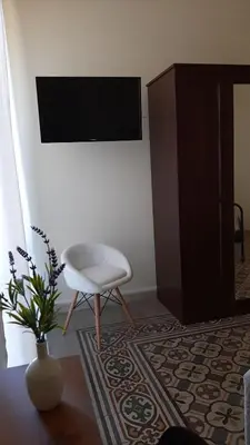 a living room with a white chair and a tv at 