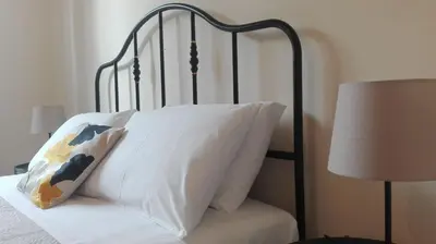 a bed with a black frame and a pillow and a lamp at 