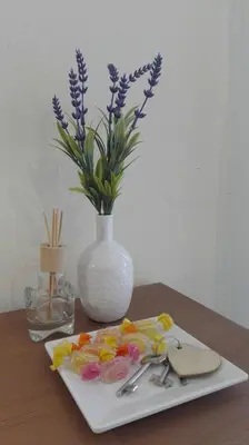 a table with a plate with a vase with purple flowers at 