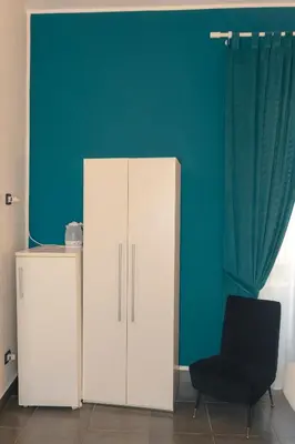 a white cabinet and a black chair in a room at Rooms 19 - Rooms and Breakfast in Palermo