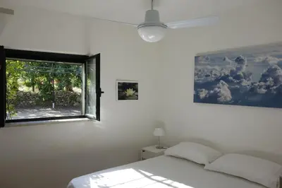 a bedroom with a bed and a window at Egesta, villa with private pool in Calatafimi