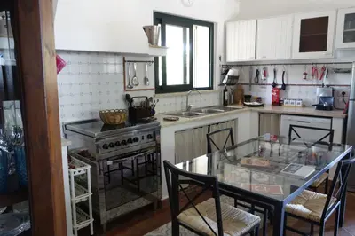 a kitchen with a glass table with chairs and a stove at Egesta, villa with private pool in Calatafimi