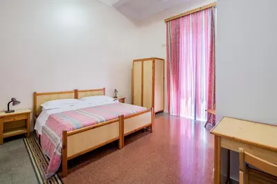 a bedroom with a bed and a large window at B&B Castiglia in Palermo