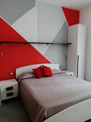 a bedroom with a bed with a red wall at B&B 