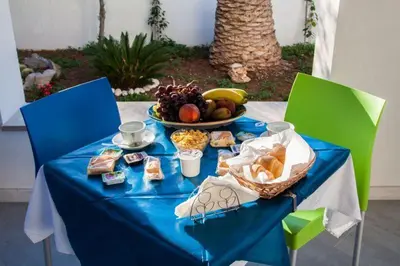 a blue table with a plate of food and a bowl of fruit at B&B 