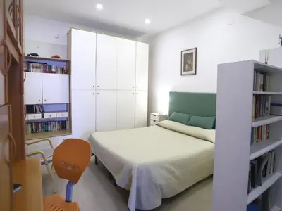 a bedroom with a bed and a book shelf at Plumeria/Libertà in Palermo