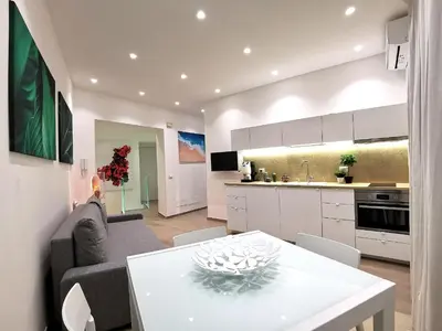 a kitchen and living room with a table and a couch at Betta splendens in Palermo