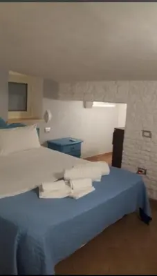 a bedroom with a blue bed with towels on it at Hostel Centro BASEMENT in Palermo