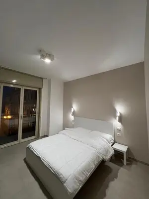 a bedroom with a large white bed and a window at CESARE ROOMS in Palermo