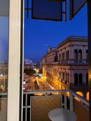a view of a city street at night from a balcony at CESARE ROOMS in Palermo