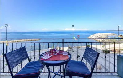 a table and chairs on a balcony overlooking the ocean at La Casa Sul Mare in Trappeto