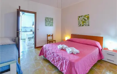 a bedroom with a pink bed with towels on it at La Casa Sul Mare in Trappeto