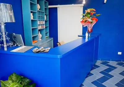 a blue room with a desk with a vase of flowers at villa oltremare resort in Bagheria