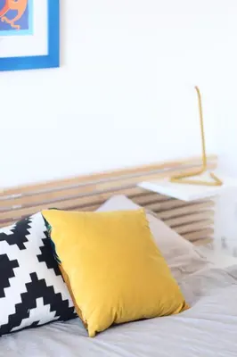 a yellow pillow sitting on top of a bed at Seaview Apartments in Palermo