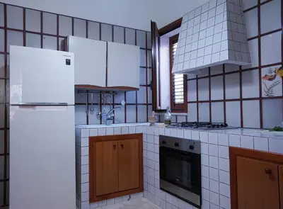 a kitchen with a white refrigerator and a stove at Villa Caterina Scopello in Scopello