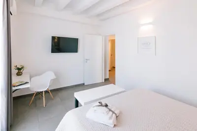 a white bedroom with a bed and a desk at Boutique BnB Dolcevita in Palermo