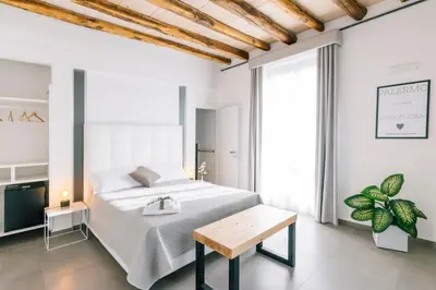a white bedroom with a bed and a table at Boutique BnB Dolcevita in Palermo