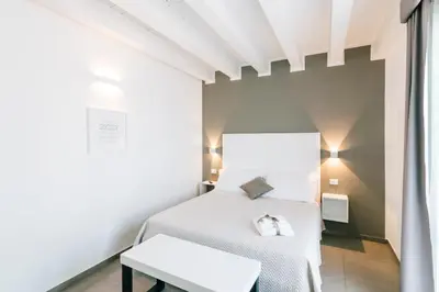 a bedroom with a white bed and a table at Boutique BnB Dolcevita in Palermo