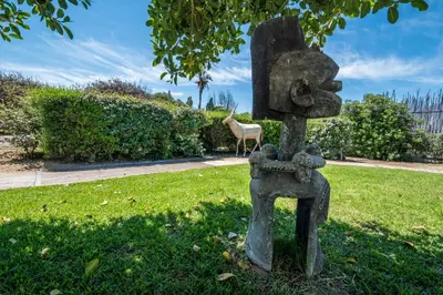 a statue in the grass with a deer in the background at B&B Le Dune - Self Check in in Lascari
