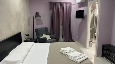 a bedroom with a bed and a chair with towels on it at Palazzo Liberty in Monreale