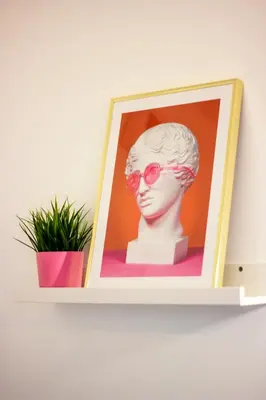 a picture of a head and a plant on a shelf at SuperAttico Bella Bellù in Palermo
