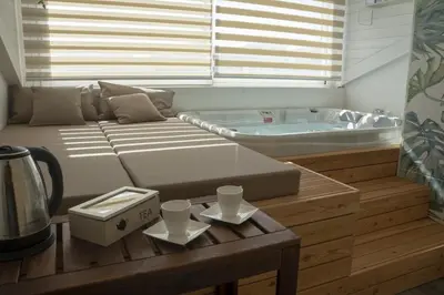 a living room with a couch and a tub at Luxmarì Hotel & Spa in Castellammare del Golfo