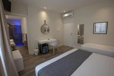 a bedroom with a bed and a sink and a bathroom at Luxmarì Hotel & Spa in Castellammare del Golfo