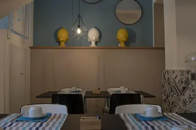 a dining room with a table and chairs and a mirror at Luxmarì Hotel & Spa in Castellammare del Golfo