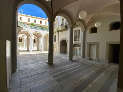 an empty courtyard of a building with columns at One in Palermo