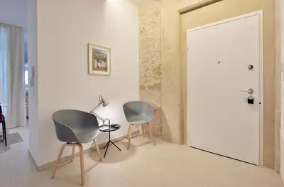 two chairs and a table in a room with a door at One in Palermo
