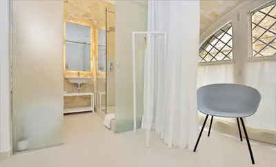 a white room with a chair and a sink at One in Palermo