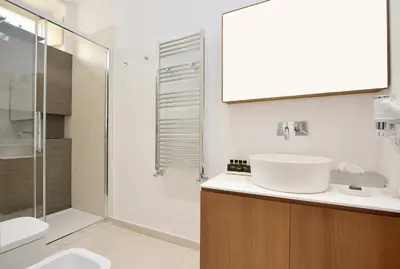 a white bathroom with a sink and a shower at One in Palermo
