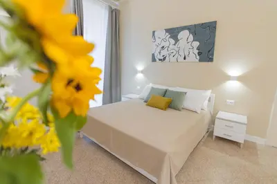 a bedroom with a bed with a yellow flower in the foreground at Donna Isa B&B in Palermo