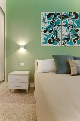 a bedroom with a bed and a painting on the wall at Donna Isa B&B in Palermo