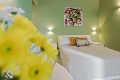 a living room with a white couch and a bed at Donna Isa B&B in Palermo
