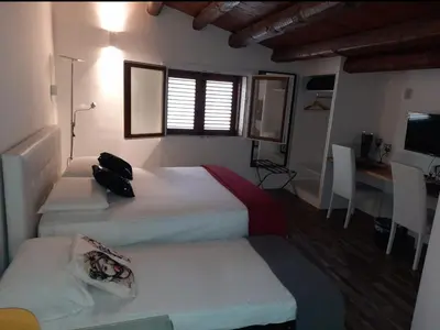 a bedroom with two beds and a desk with a computer at San Francesco Rooms and Apartment with Terrace in Palermo Locazione Turistica in Palermo