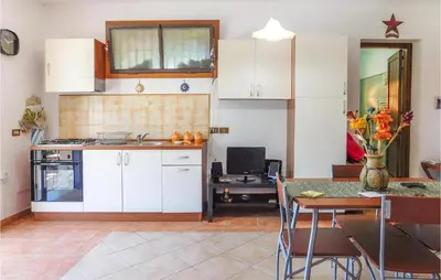 a kitchen with white cabinets and a table with chairs at Mages in Casteldaccia