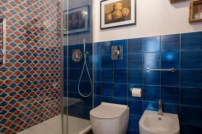 a blue tiled bathroom with a toilet and a shower at il Palchetto B&B di Charme e Design in Palermo