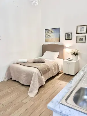 a white bedroom with a bed and a sink at Giulio Cesare 14, Residence in Palermo
