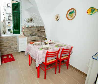 a dining room with a table with red chairs at La maison à la cathedral in Palermo