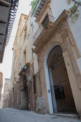 an old building with a large door in a street at La maison à la cathedral in Palermo