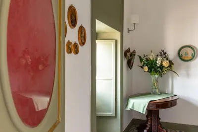 a hallway with a vase of flowers and a mirror at Ajutamicristo Domus by DomuSicily in Palermo