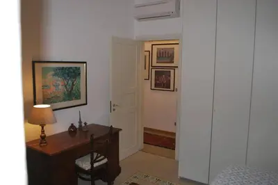 a room with a desk with a lamp and a door at casa immersa nel verde al centro di Palermo in Palermo