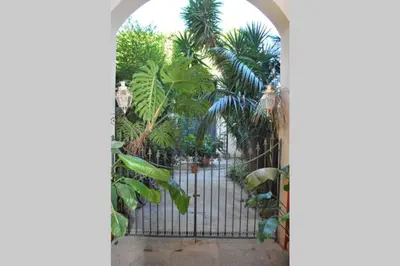an open gate with palm trees behind it at casa immersa nel verde al centro di Palermo in Palermo