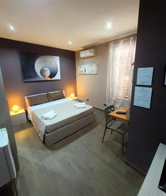 a bedroom with a bed and a table and a desk at B&B Rampante in Piana degli Albanesi
